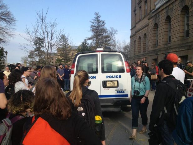 Protesters surround and observe a police van